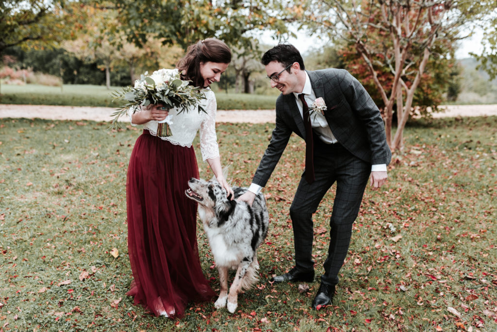 Les mariés caressent leur chien.
