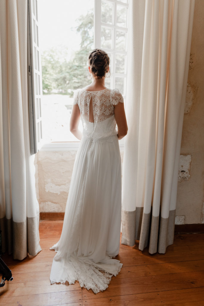 Portrait d'une mariée regardant par la fenêtre
