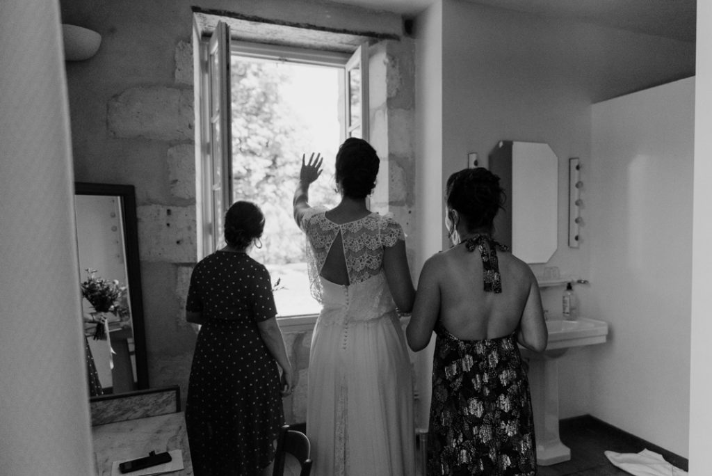 Mariée faisant bonjour par une fenêtre