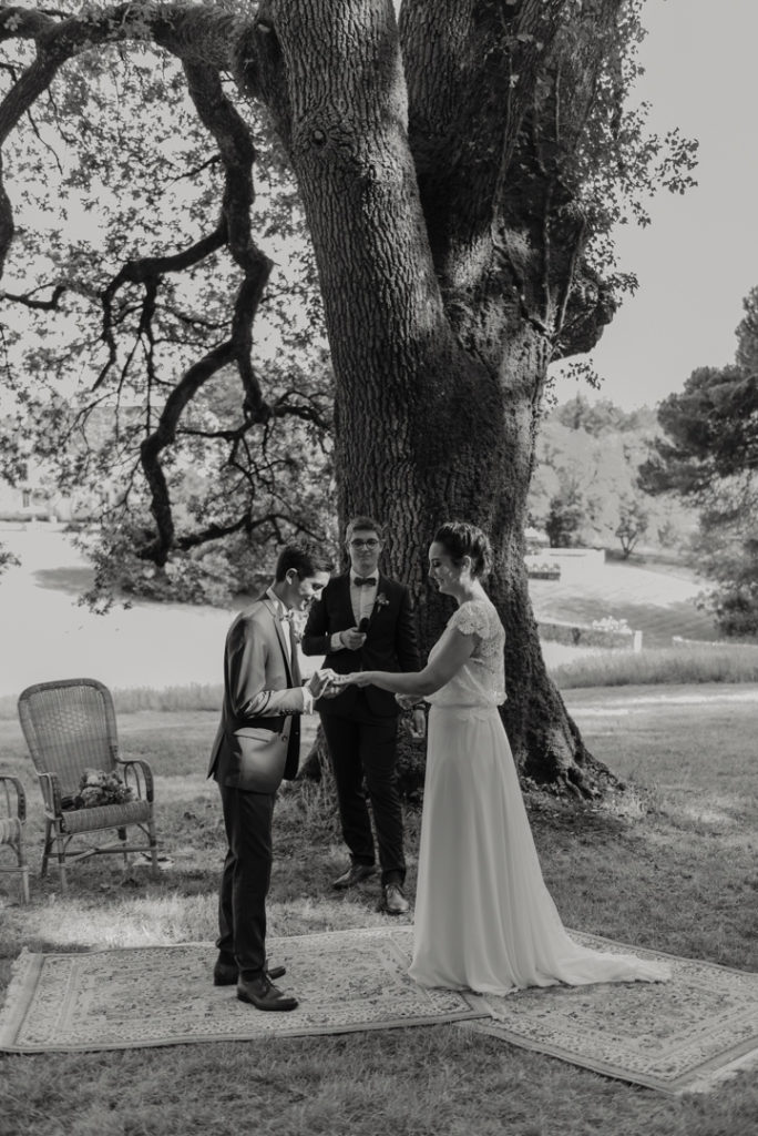 Marié passe l'alliance au doigt de la mariée