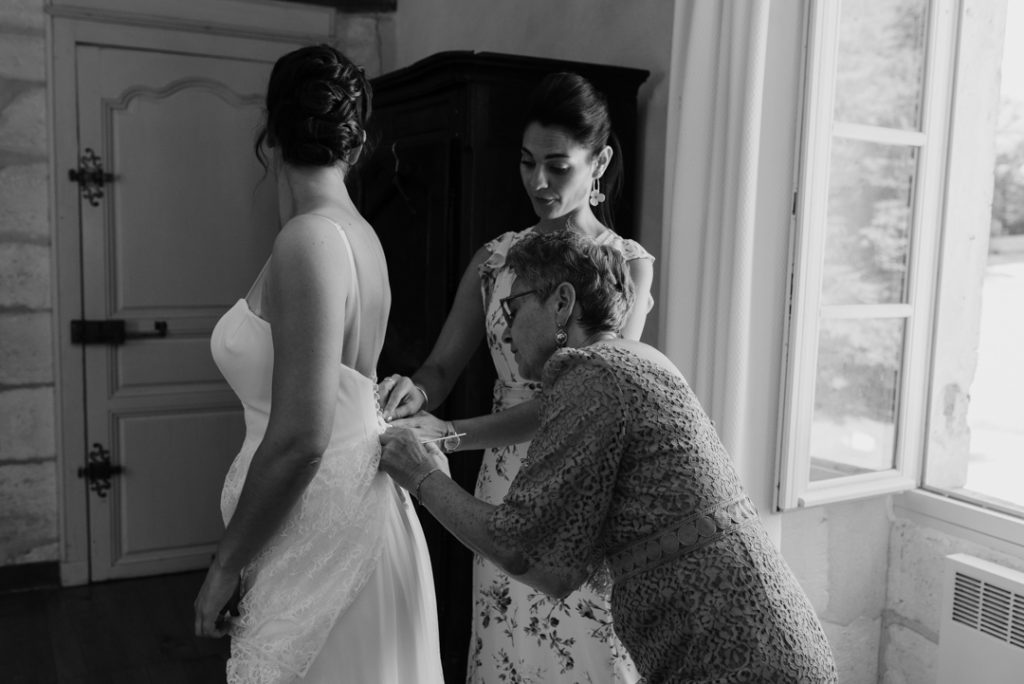 Maman et soeur de la mariée l'habillant