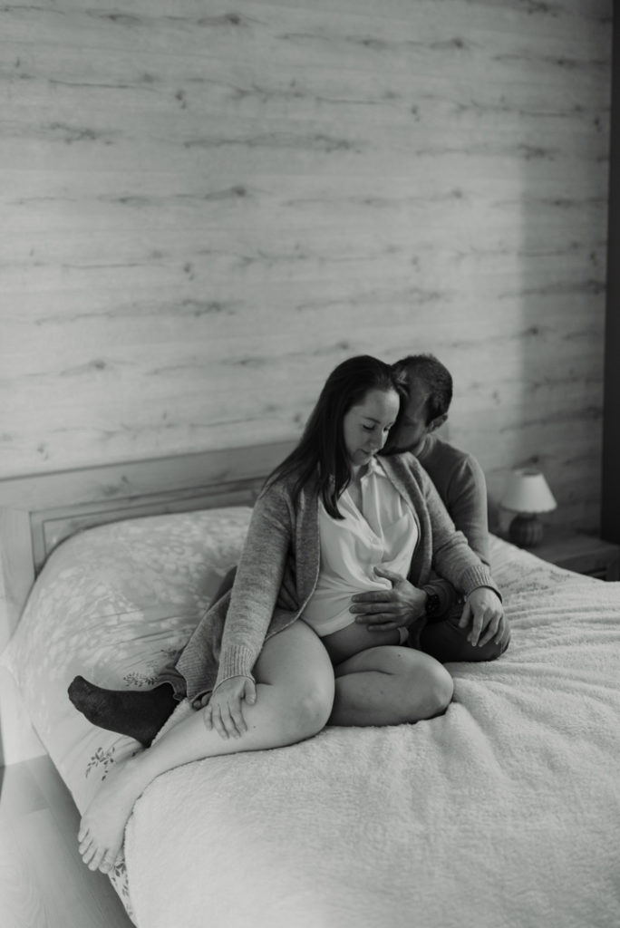 Futurs parents assis sur un lit