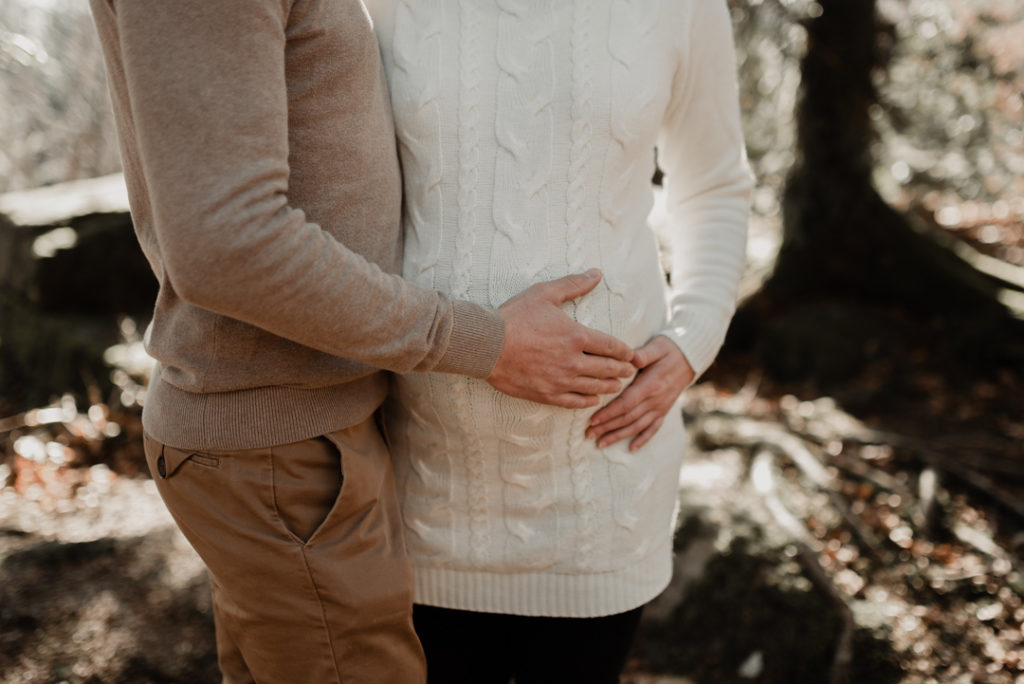Homme ayant ses mains posées sur sa compagne enceinte