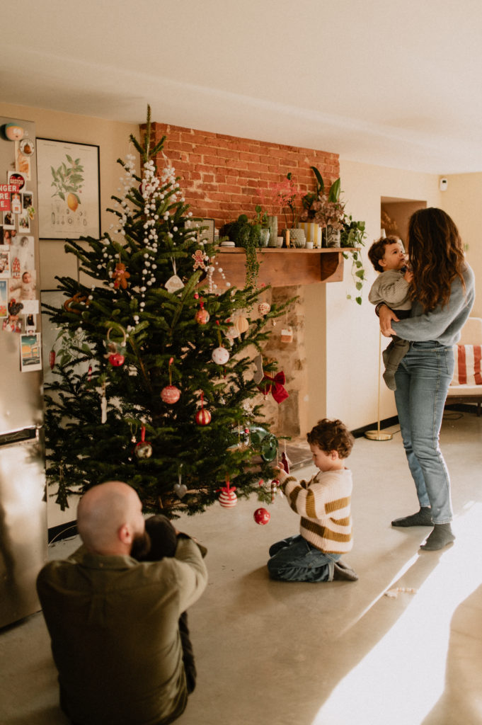 Photographie d'une famille autour d'un sapin de Noël