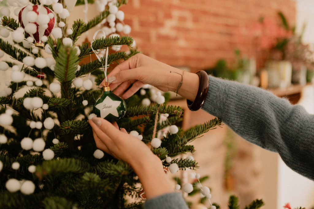 Une maman mettant dans le sapin une boule de Noël